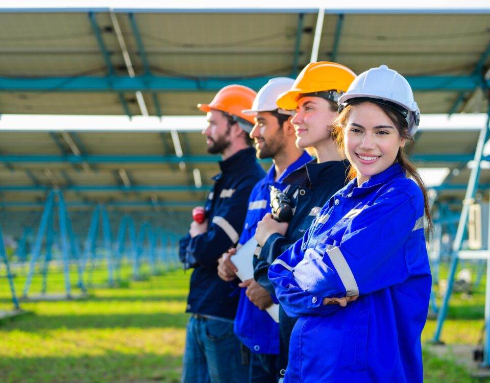 Engineers and workers installing solar panels at a large solar farm