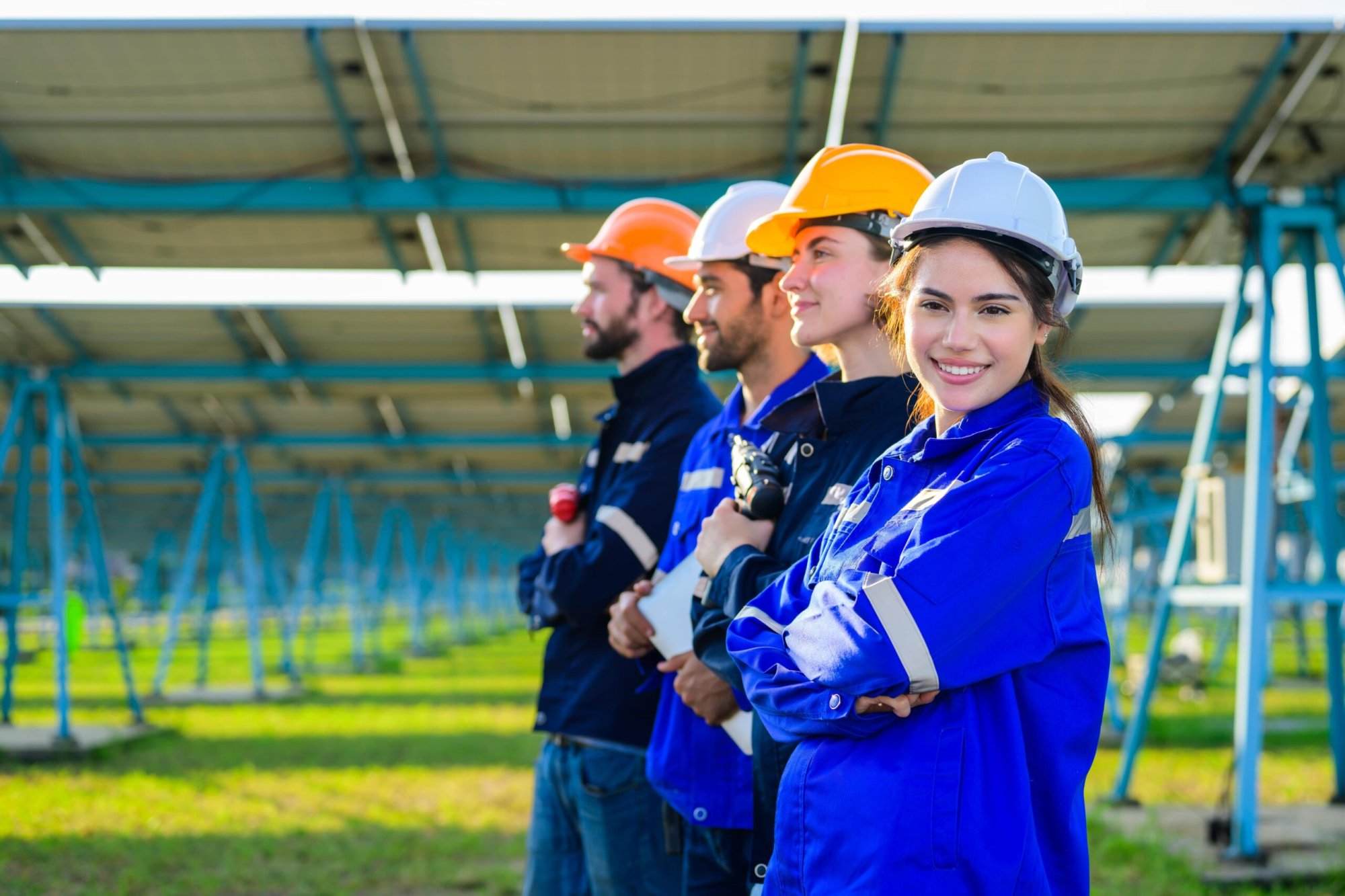 Engineers and workers installing solar panels at a large solar farm